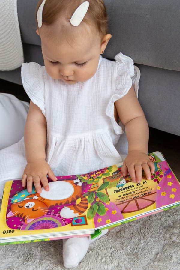 Bebé de 6 meses con las manos sobre un libro Alimax